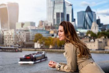 A beautiful, brunette tourist woman enjoys the view of the skyline of London, United Kingdom australian woman in London United Kingdom