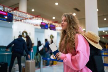holiday-travel-tips-hero a young woman queuing at the airport, avoiding crowds by following clever holiday travel tips