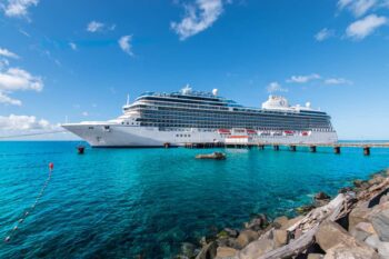international-cruise-tips Oceania Vista cruise ship docked in Roseau, Dominica, where passengers are enjoying their trip having read the best cruise tips