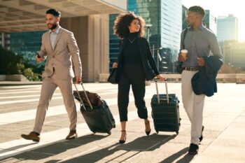 corporate-team-with-suitcases A group of business travelers walking through a city with suitcases, highlighting the importance of global insurance for employees