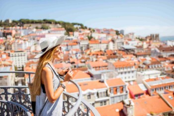 a female tourist overlooking Lisbon, indicating the importance of buying travel insurance for Portugal