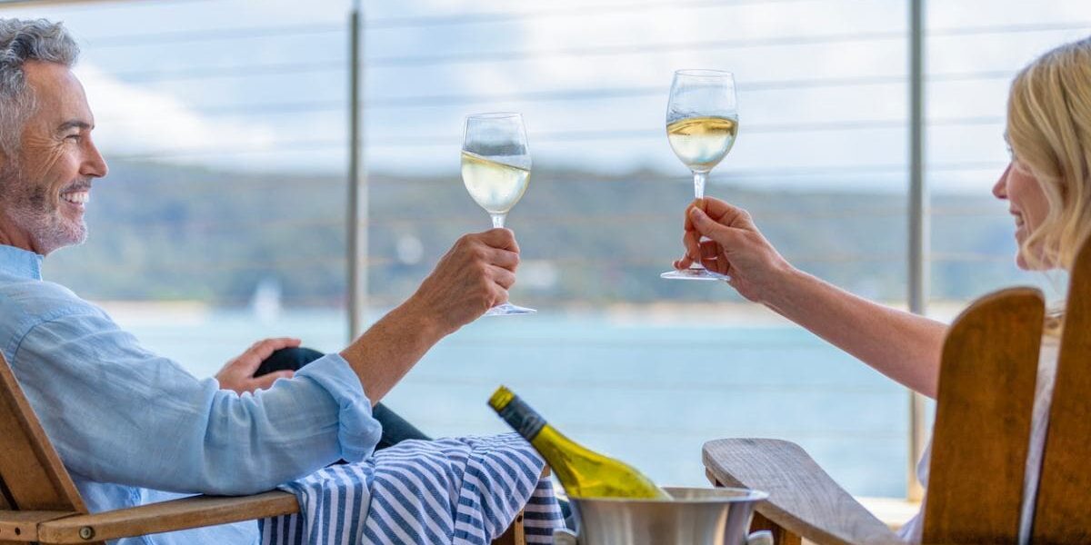 couple-drinking-wine-on-ship A mature couple drinking wine on the deck of a ship having researched cruise tips for