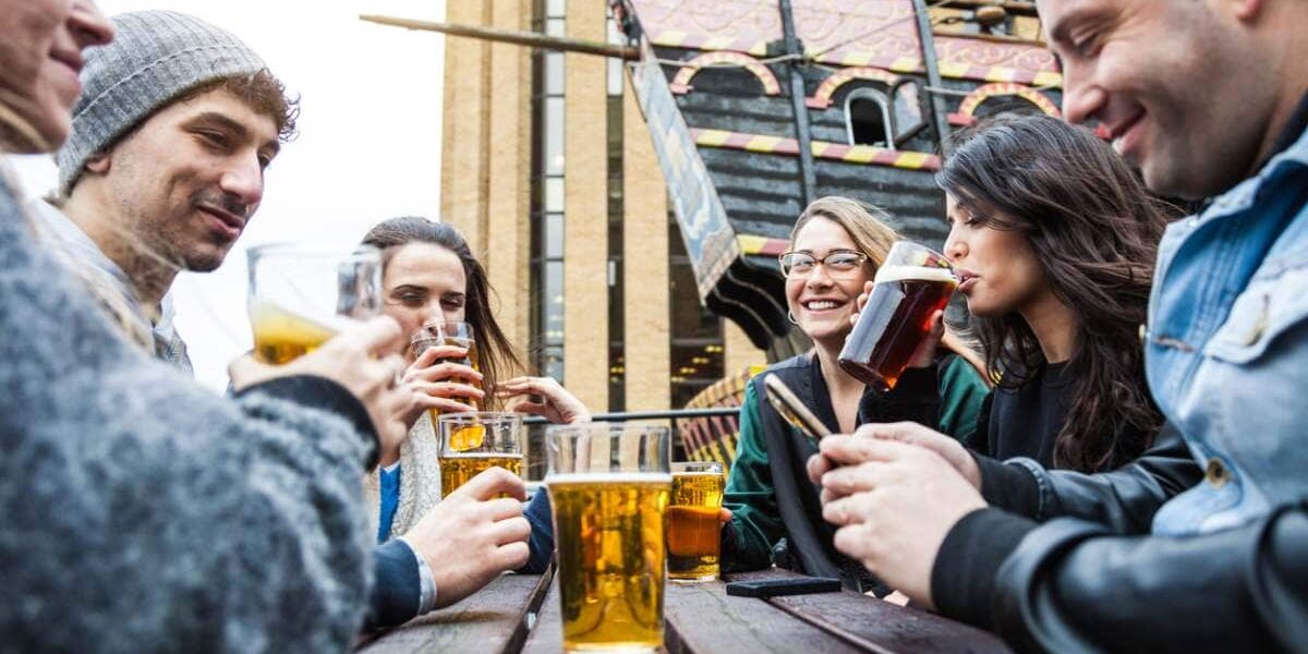 friends-drinking-beer friends drinking beer outside a London pub, where tourists are advised to purchase UK travel insurance