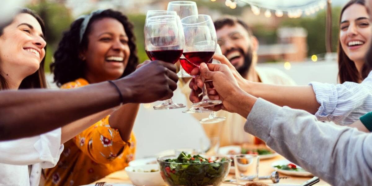friends-drinking-wine a group of friends smiling and drinking red wine in Spain, one of the healthiest countries in the world
