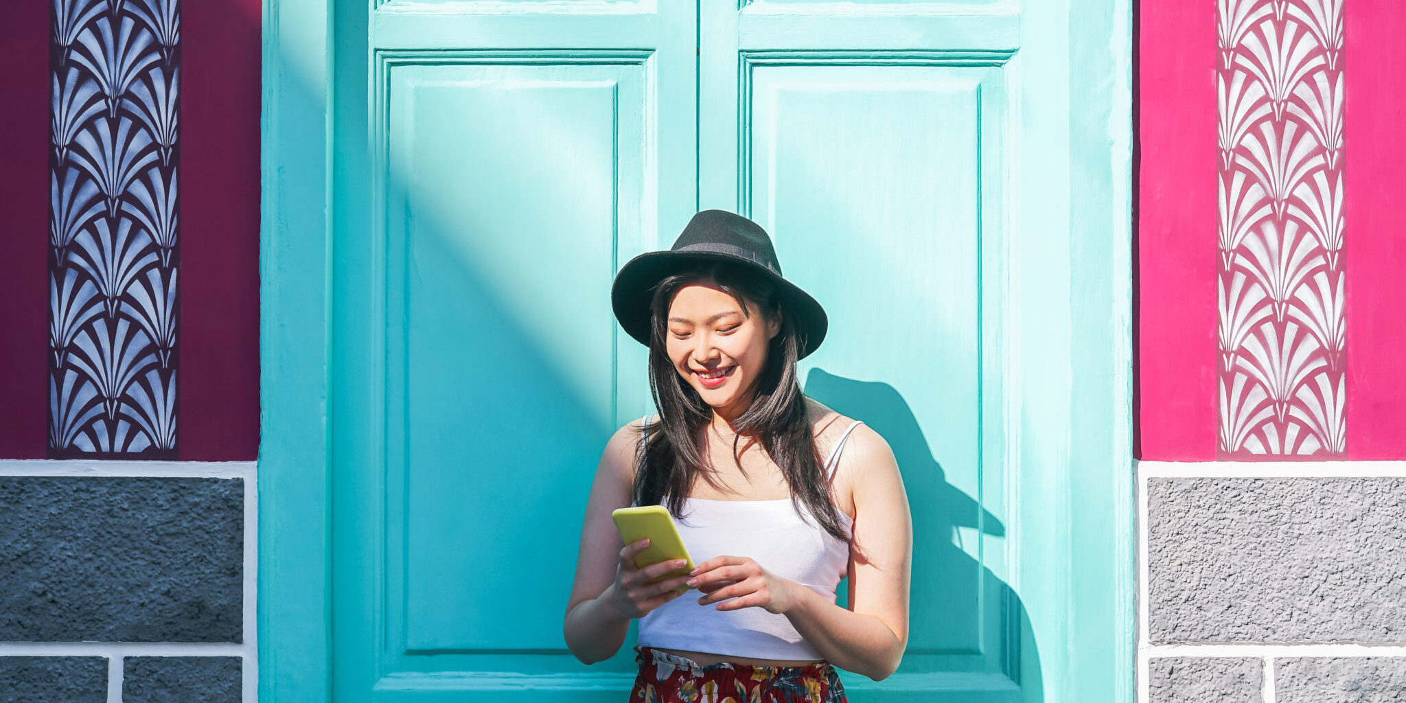 Happy Asian woman using mobile smart phone outdoor - Chinese fashion girl watching on new trends social networks - Web influencer, millennials, technology and generation z concept a happy girl using an app to manage her money, one of our top study abroad tips for students