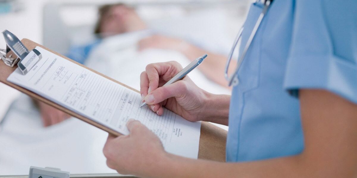 hospital-paperwork a doctor filling in paperwork for a patient in a country with a reciprocal healthcare agreement