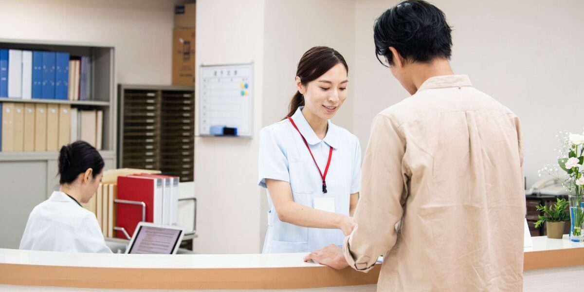 hospital-reception-japan a man paying a medical bill at a Japanese hospital, highlighting the important of securing travel insurance for japan
