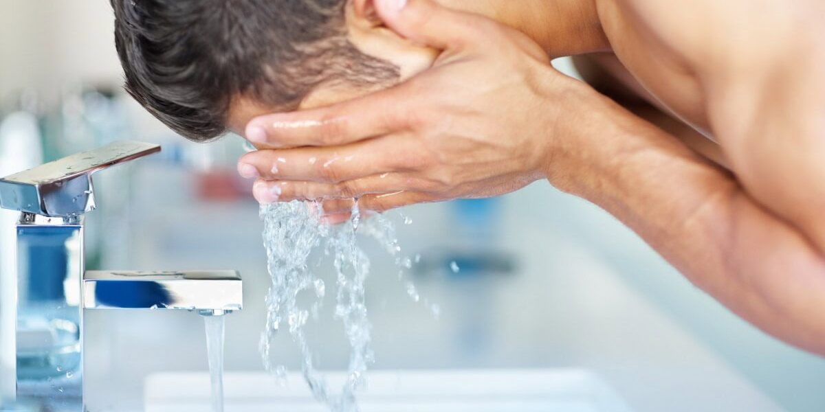 man-washing-face a man washing his face and keeping it clean from pollution, one of the best skin care tips for living abroad