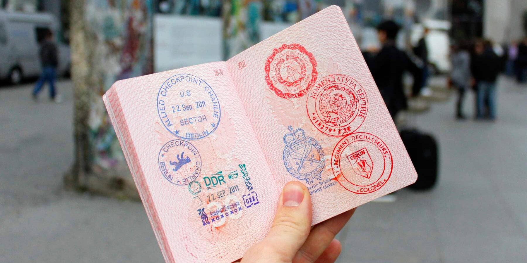 passport-with-stamps a hand holding a passport full of colorful stamps for different countries