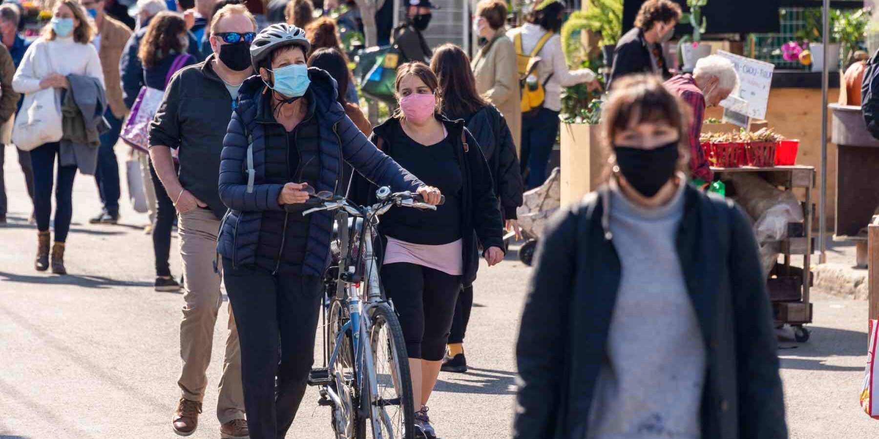 people-wearing-covid-face-masks- people wearing Coronavirus face masks at Jean Talon Market in Montreal, reflecting the strain the pandemic placed on the Canadian healthcare system
