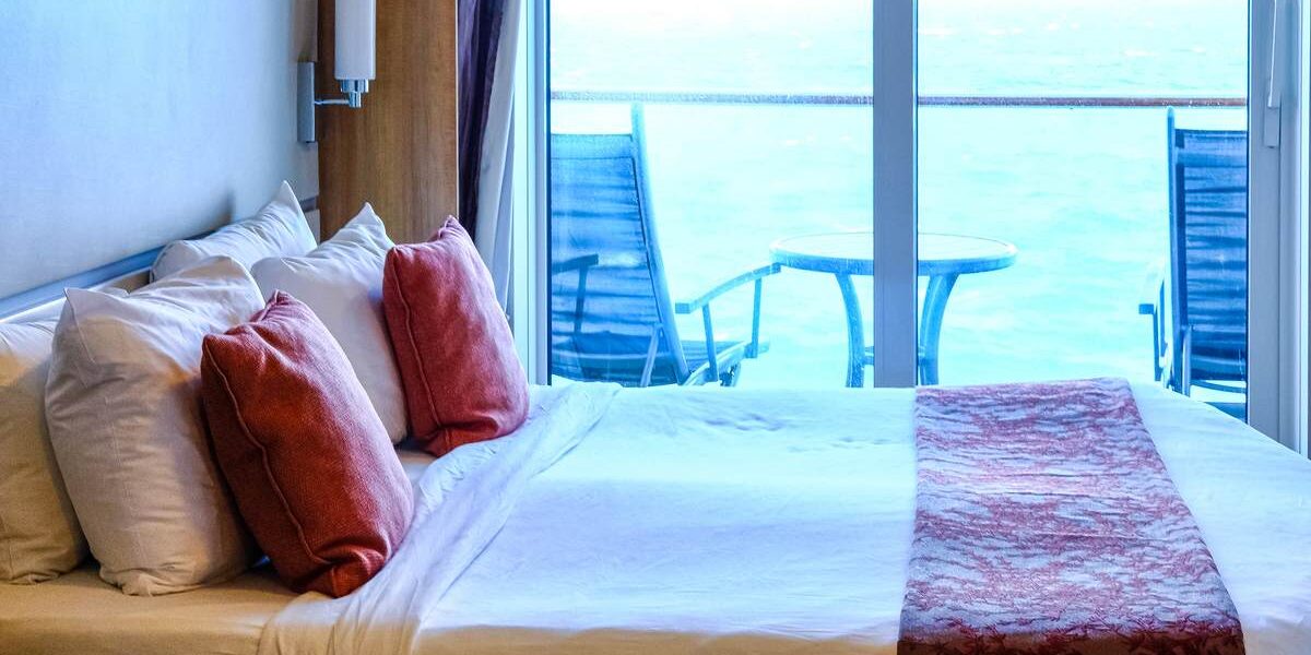 room-on-cruise-liner a bedroom on a cruise liner, with a window showing the horizon; one of the best cruise tips to avoid seasickness