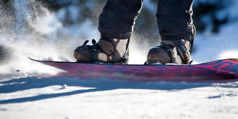 snowboard-on-slope a close-up shot of a snowboard sliding down a snowy slope