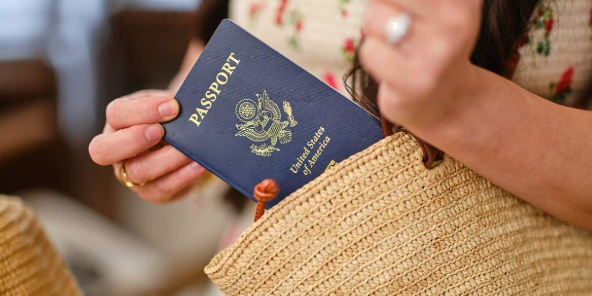 us-passport-holder a woman reaching for her US passport which is linked to her ETIAS application for Europe