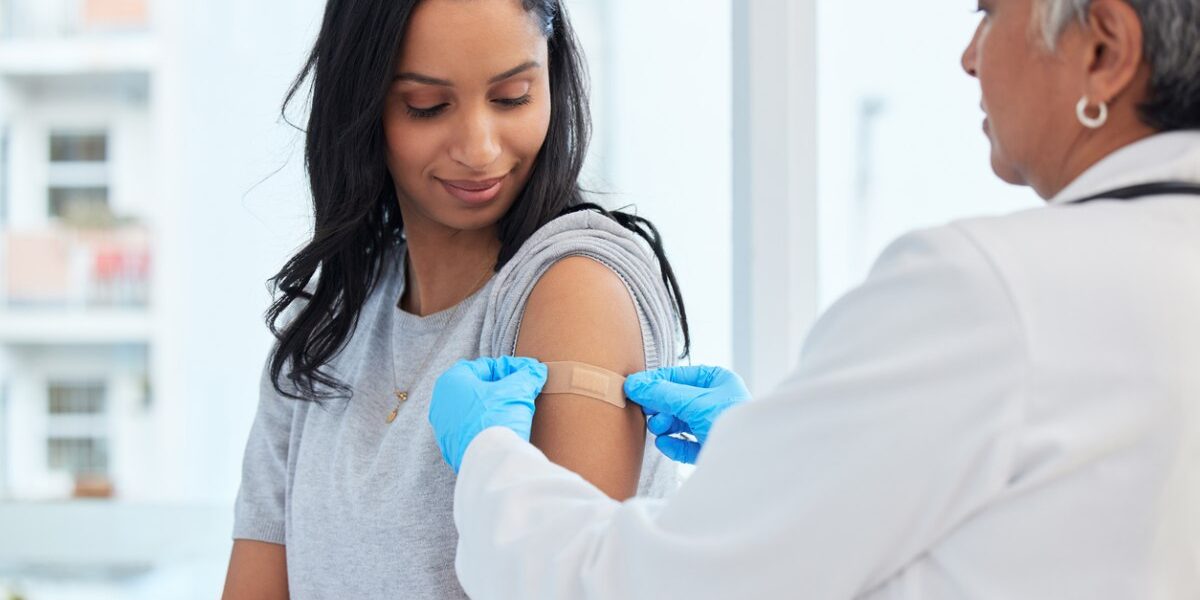woman-getting-vaccination a woman getting a shot to make sure she meets the vaccination requirements for traveling abroad