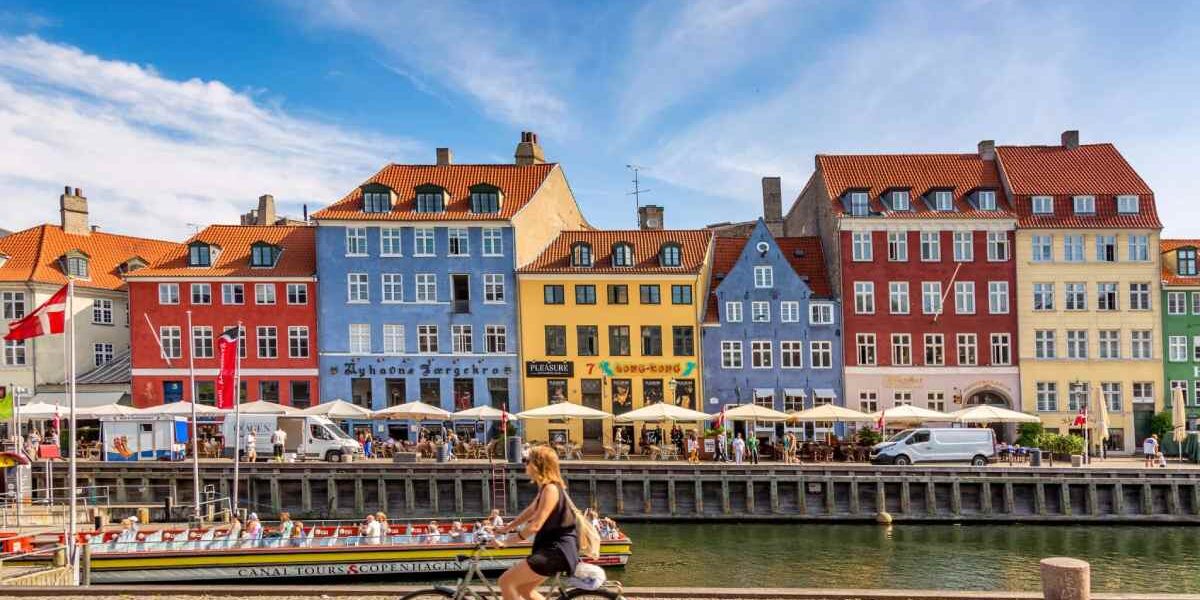 woman-on-bike-in-copenhagen-denmark a woman cycling a bike in Copenhagen, one of the best countries to live in as an expat