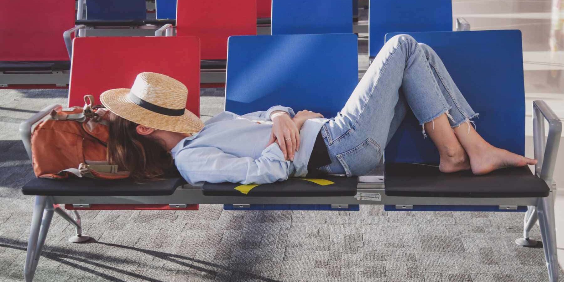 woman-sleeping-in-airport a tired woman taking a nap in an empty airport while she waits for her flight